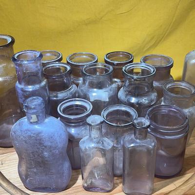 Collection of antique amethyst and clear glass apothecary bottles