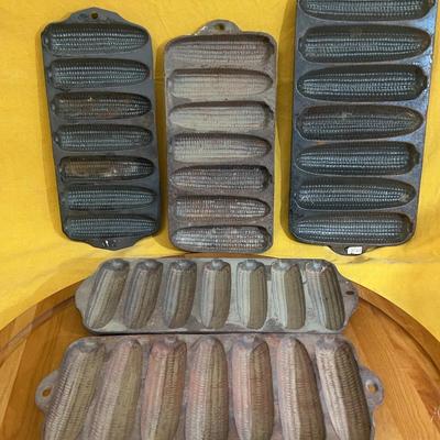 A set of five vintage cast iron corn stick pans, including Wagner Ware