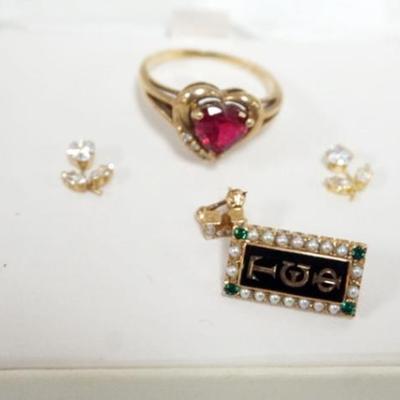 Sale Photo Thumbnail #178: 1170	10K GOLD ASSORTED JEWELRY INCLUING CZ FLOWER EARRINGS, RED HEART STONE RING APPROXIMATE SIZE 9 1/4 AND FRATERNITY PIN WITH STONES
