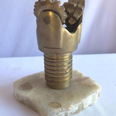 miniature PDC (Polycrystalline Diamond Compact) drill bit model mounted on an onyx base.