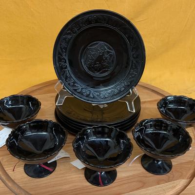 Black depression glass set with clover leaf pattern bowls and plates.