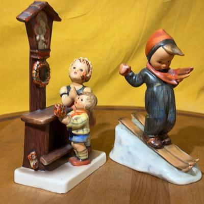 Set of two Goebel Hummel ceramic figurines: a skier and children at a shrine