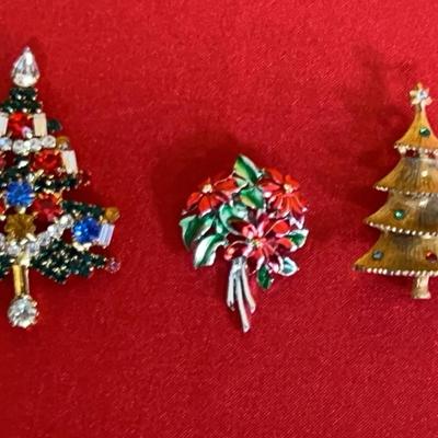 Three vintage Christmas-themed costume jewelry brooches
