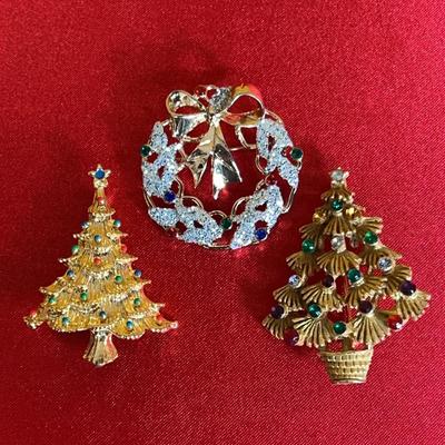 A set of three vintage gold-tone Christmas brooches with rhinestones