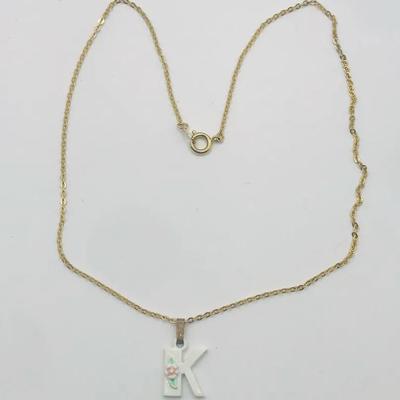 Gold Tone Chain Necklace With A White Initial "K" Pendant Featuring A Small Pink Floral Detail