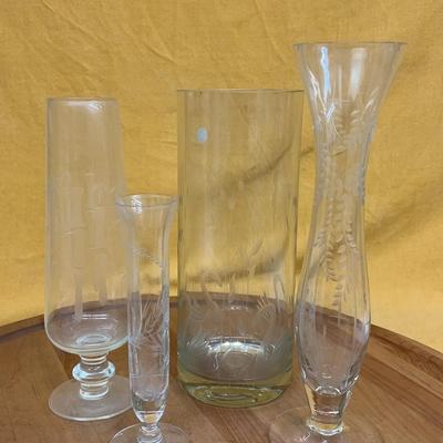A collection of four vintage clear glass vases with etched decorative patterns