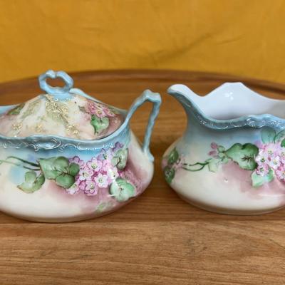Vintage hand-painted porcelain creamer and sugar set with floral motifs
