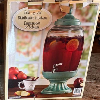 Sale Photo Thumbnail #109: This is a glass beverage dispenser with a stand. 
Made from thick, durable glass. 
Features a spigot for easy pouring and a lid to keep drinks fresh. 
Wide mouth opening makes it easy to fill
