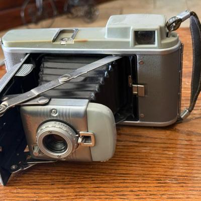 Sale Photo Thumbnail #114: This is a vintage Polaroid Land Camera Model 80, also known as the "Highlander". 
It was introduced by Polaroid in 1954 as a smaller, budget-priced camera. 
