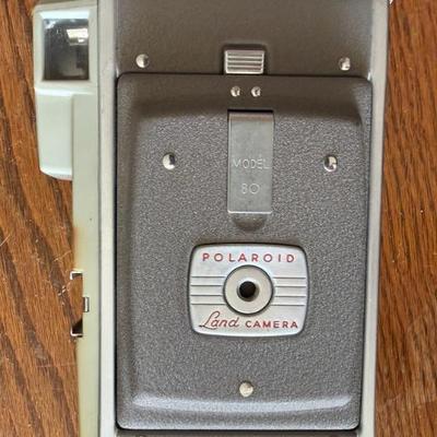 Sale Photo Thumbnail #113: This is a vintage Polaroid Land Camera Model 80, also known as the "Highlander". 
It was introduced by Polaroid in 1954 as a smaller, budget-priced camera. 
