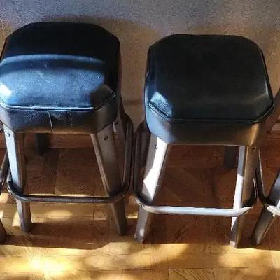 FOUR BLACK CUSHION BARSTOOLS