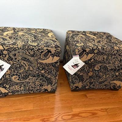 pair of square storage ottomans with a black and gold paisley-like pattern