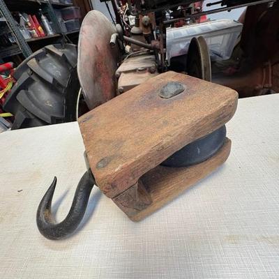 vintage or antique single-rope wooden block and iron farm pulley