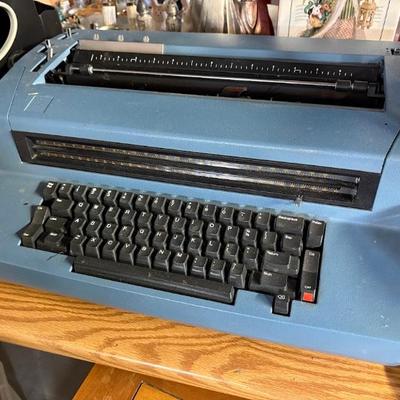 IBM Selectric II or Selectric III electric typewriter in blue.  It features a unique "golf ball" type element that rotates and...