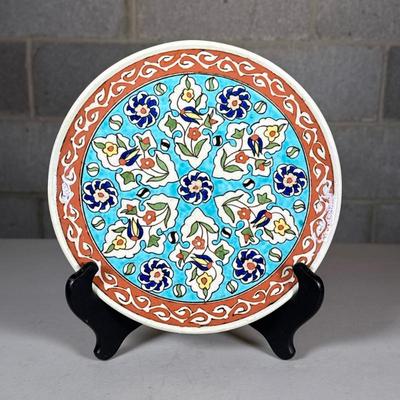 Signed Painted Pottery Plate | Colorful flower decoration with impressed stamp mark to underside Dimensions: dia. 8.5 in
