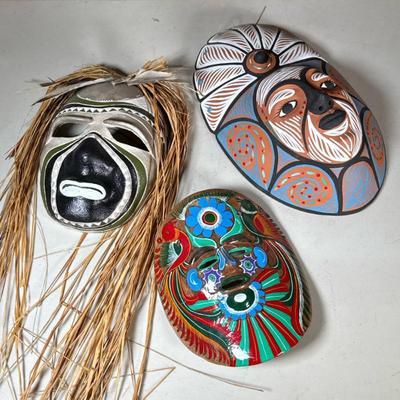 (3pc) Painted Pottery & Ceramic Masks | Colorfully decorated masks, including one with raffia hair and feather accents, a stylized...