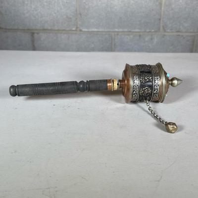 Tibetan Prayer Wheel | Mixed metals with a wood handle, the lid with three light turquoise cabochons Dimensions: l. 12 x dia. 2.75 in
