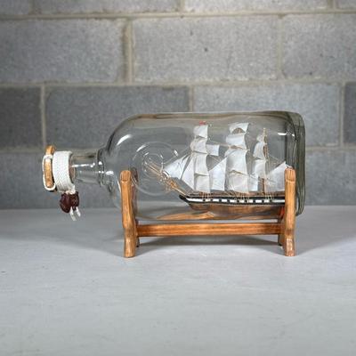 Ship in a Bottle | On a wood display stand with metal plaque reading Boemor 1818 Dimensions: l. 9 in (bottle)
