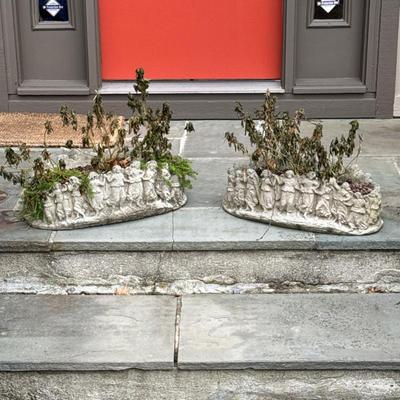 PAIR CONCRETE FIGURAL PLANTERS | Cast garden planters with continuous relief of dancing classical figures encircling the exterior; heavy...