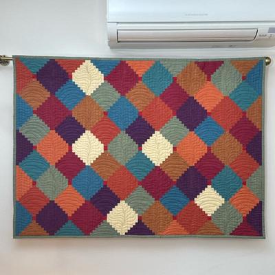 Colorful Quilted Wall Hanging | On a brass hanging rod, featuring a repeating pattern, finished with a bound edge Dimensions: h. 33.25 x...