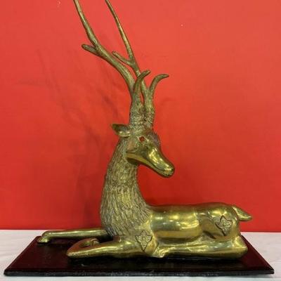 Large mid-century brass reclining stag deer sculpture with carnelian eyes, mounted on wood base, 19” x 21”