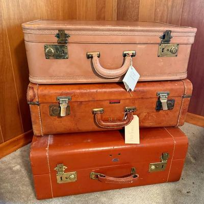 Three vintage suitcases full of linens