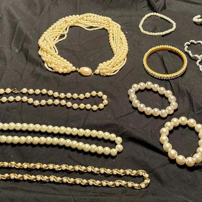 Costume jewelry featuring imitation pearls and gold/silver tone metal. 