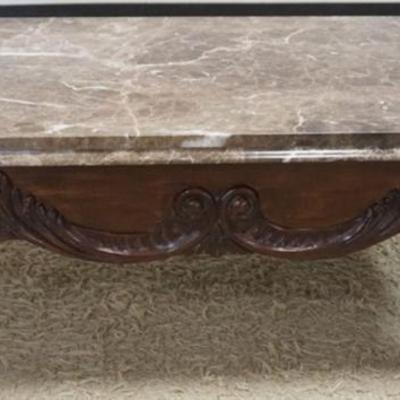 Sale Photo Thumbnail #218: 1219	MARBLE TOP COCKTAIL TABLE WITH HEAVY CARVED WOODEN BASE, APPROXIMATELY 52 IN X 32 IN X 19 IN H
