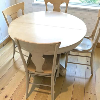 White round dining table with four matching chairs