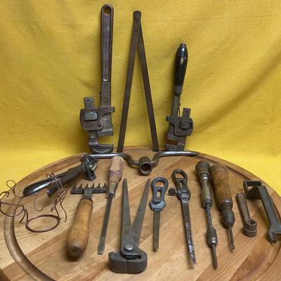 Collection of assorted antique hand tools including pipe wrenches and pliers