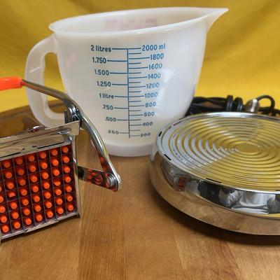 Collection of vintage kitchenware including a manual slicer and electric warmer