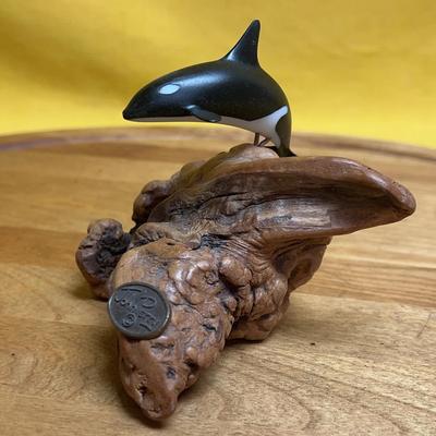 A John Perry carved orca sculpture mounted on a driftwood base