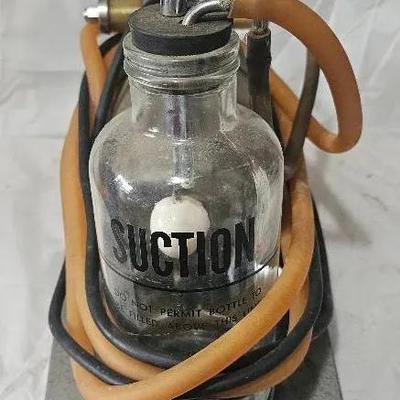 Vintage early electric medical suction pump apparatus with glass collection jar.