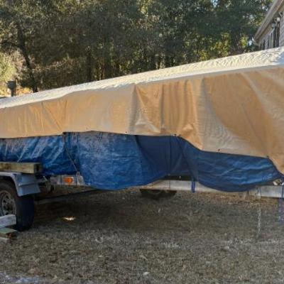 Covered boat on trailer with tarp