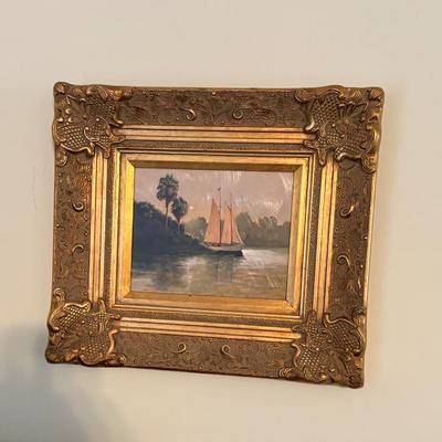 Framed sailboat painting, appears oil on board; ornate gilt frame, coastal nautical artwork.