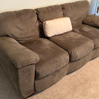 Brown upholstered sofa, appears microfiber; three-seat couch with loose cushions, neutral living room seating