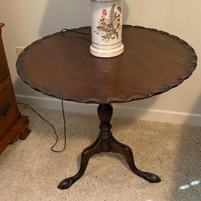 Round Wooden Pedestal Tablewith a scalloped edge top and tripod-style base; likely used as a dining, accent, or lamp table.