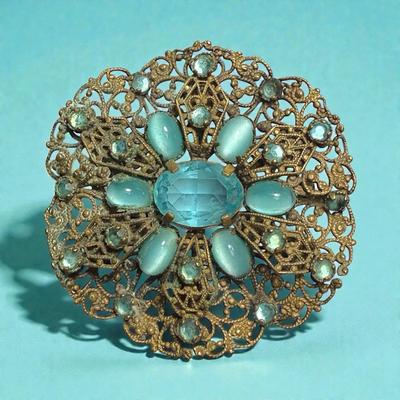 Edwardian style filigree metal brooch with aqua blue stones