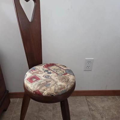 vintage three-legged wooden stool with a heart-shaped cutout backrest 