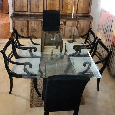 Dramatic Dining Table In Glistening Glass With Black Chairs