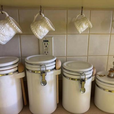 White Ceramic Kitchen Canister Set with Hanging Embossed Mugs and Chef Figurine Lid Accent