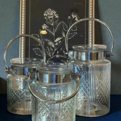 Three hurricane lamps with handles framed art