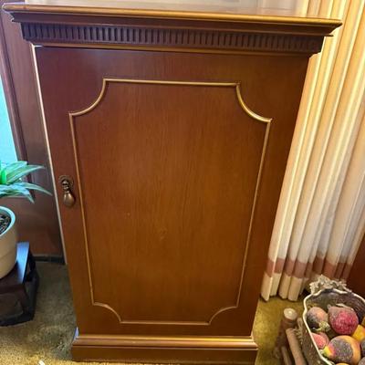 This item is a traditional-style single-door wooden cabinet or accent cabinet with a warm finish and