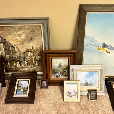 11 Framed Oil & Acrylic Paintings By Various Artists. Themes Include Seaside, Skiing, Cities/Travel