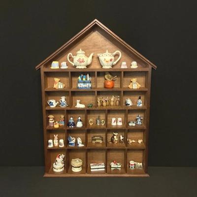 Collection Of Miniature Figurines On A House Shaped Shelf 