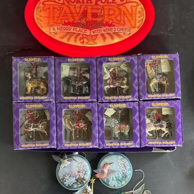 Christmas Carousel Ornaments In Boxes With Others And A Lighted Christmas Sign 