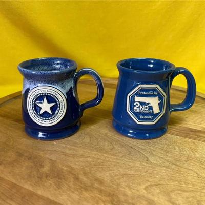 Two contemporary hand-thrown artisanal ceramic mugs with themed decals
