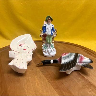 A collection of three vintage ceramic figurines: a McCoy wall pocket, a boy, and a duck