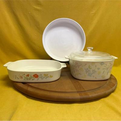 A set of three CorningWare bakeware pieces with floral and white patterns
