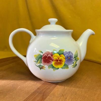 A white Corelle ceramic teapot with a "Summer Blush" pansy floral pattern